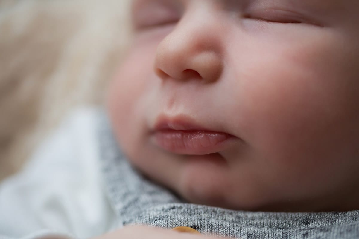 Nahaufnahme des Gesichtes eines neugeborenen Babys das waehrend eines neugeborenen Fotoshootings in Donna Bellini Foto-Studio Berlin schlaeft
