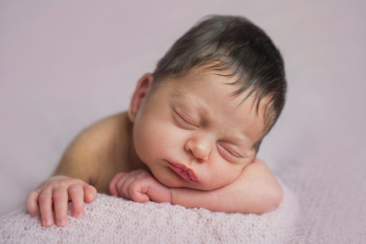 Neugeborenes schlaeft auf dem Bauch waehrend eines neugeborenen Fotoshootings im Donna Bellini Photo Studio Berlin