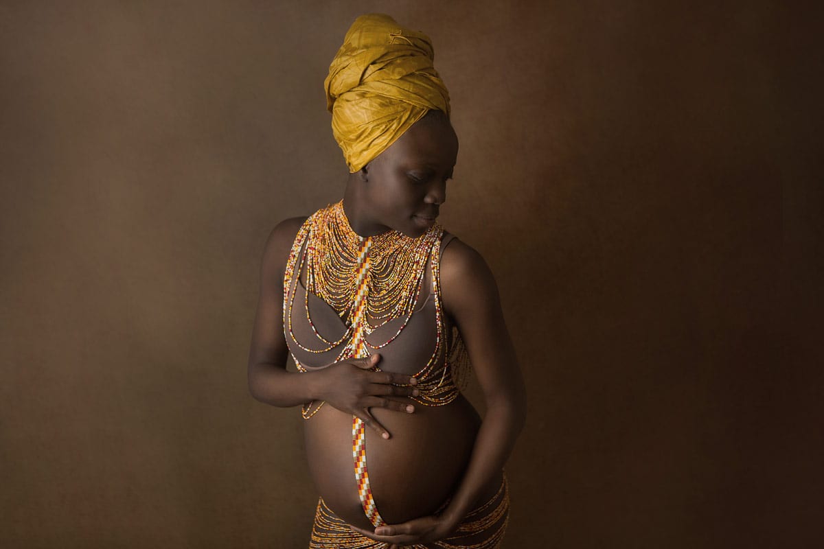 Schwangere Frau mit goldenen Outfits posiert fuer ein Schwangerschaftsfotoshooting von Donna Bellini Berlin